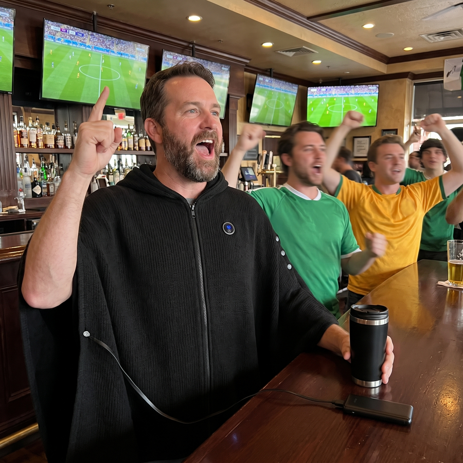 Man cheering in a sports bar wearing the heated poncho